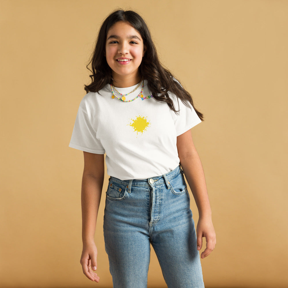 Child wearing a white SMUDGE youth t-shirt with the Yellow Splash design, front view, studio backdrop