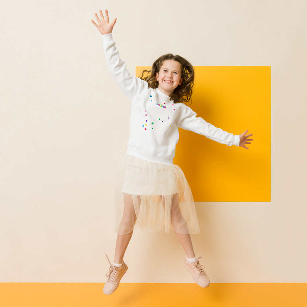 Child wearing a white SMUDGE youth sweatshirt with the Splash Scatter design, front view, studio backdrop